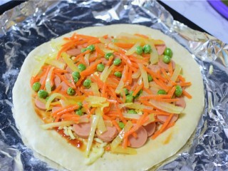 10、火腿披萨,再将炒过的胡萝卜，洋葱，豌豆火腿放上面