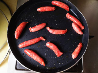 4、大米披萨,平底锅里放入少许食用油，把宝宝肠放进去煎熟，注意火候，不要煎糊了，