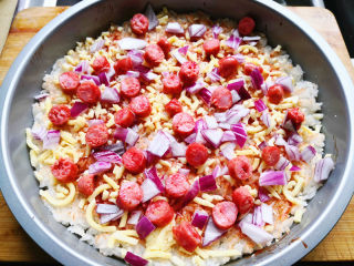 7、大米披萨,把切好的洋葱撒在披萨上，再把宝宝肠丁也撒上去，撒的时候注意均匀点