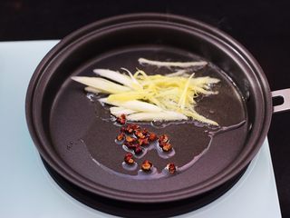 6、茄条炒海虹,放入花椒小火慢慢炒出香味,再放入葱姜丝爆香。