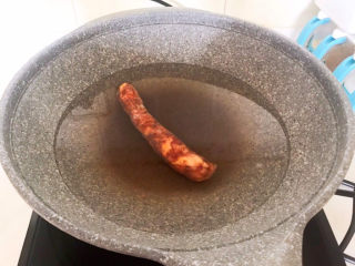 1、冬至美食   快手菜腊肠炒萝卜,四川腊肠提前放入锅中煮20分钟，煮熟后捞出来备用