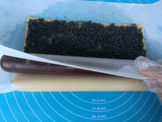 11、年轮卷卷饼干,擀面杖放在靠近身体的一侧油纸下面。