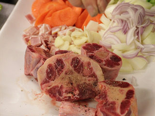 2、番茄红酒烩牛尾,洋葱，西芹，胡萝卜，大番茄切成块状，培埂和蒜切片。并在牛尾上撒上盐和胡椒