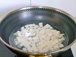 4、蒜泥螃蟹,锅中加入纯净水烧开，下豆腐块，再次烧开煮1分钟捞出。