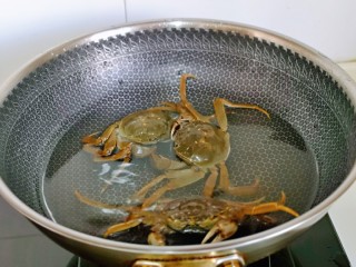 5、蒜泥螃蟹,毛蟹用牙刷刷干净，绳子解开，冷水下锅，大火烧开煮2分钟。