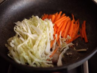 10、【爱生活.爱面条】の日式炒面,放入包菜丝和胡萝卜丝，翻炒均匀，这个时候可以适当加一些盐调味