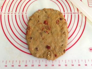 9、红枣枸杞软欧包,取一份松弛好的面团,用手拍扁,用擀面杖把面团擀成椭圆形。