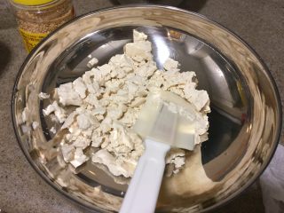 12、日式蔬菜拌豆腐,把吸干水分的豆腐，用勺子或者刮刀捣碎。