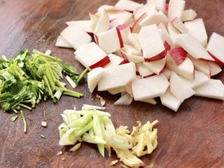 2、扇贝丁炖水萝卜,水萝卜洗净后，用刀切成薄片，香菜切段，蒜苗和姜切丝。