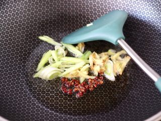 4、扇贝丁炖水萝卜,锅烧热后倒入花生油烧热，小火炸香花椒，再大火爆香蒜苗和姜丝。