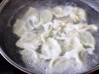14、冬至美食～牛肉茼蒿饺子,锅中倒入适量的清水煮沸后，放入包好的饺子煮沸后点少许清水，反复3次，看见所有的饺子都漂浮在水面上即可关火。