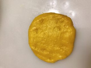 7、南瓜奶油卷,把面团拍扁。