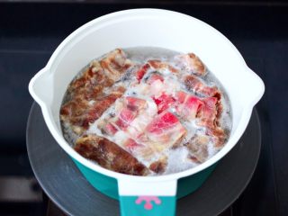 6、番茄金针菇肥牛汤,锅中倒入适量清水煮沸后，放入肥牛开始焯水。