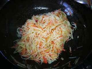 6、春饼卷三丝,放入土豆丝、胡萝卜丝和莴笋丝，加入盐和少量生抽调味，翻炒出锅。