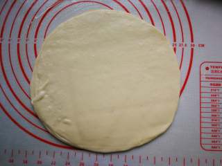 14、春饼卷三丝,先用手按压中间，再用擀面杖擀薄，大约直径22cm。剩余的面团相同的方法做完。