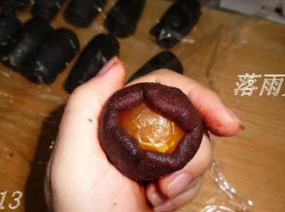 13、竹炭蛋黄酥月饼,取一块豆沙压扁，放上咸蛋黄，包成圆球