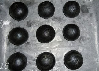 16、竹炭蛋黄酥月饼,做好的竹炭蛋黄酥摆在烤盘，表面喷层水，放入预热好190度的烤箱5分钟拿出