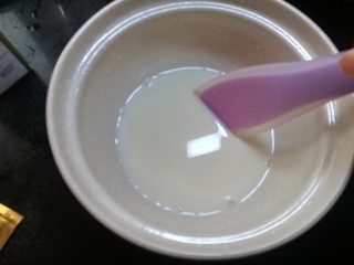 2、芒果酸奶杯,细砂糖倒入容器中，加入少量的温牛奶融化。不要一次把一升牛奶都倒进去，这样不利于菌粉和牛奶充分融合。