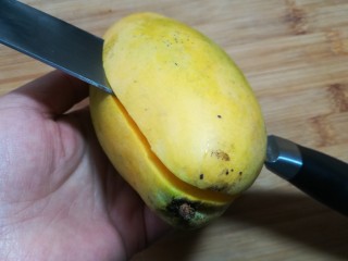 9、芒果酸奶杯,取一只芒果，从中间剖开。