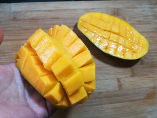 12、芒果酸奶杯,手在芒果皮位置往上一顶，芒果就会成图中的状态。这时就可以很方便的切下芒果的小块。