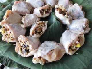 16、八宝酿鸡翅,荷叶铺在盘子上，酿好的鸡翅放入，并用荷叶包裹住，然后大火蒸40分钟