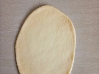 8、日式牛奶卷,取一个小面团拍扁排气，擀成长椭圆形。