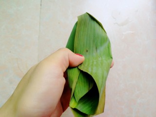 12、杂豆蜜枣小米粽,如图这样两边的粽叶往中间压，盖住小米