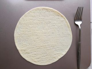 7、培根薯角薄底披萨,用叉子在面饼上刺孔。