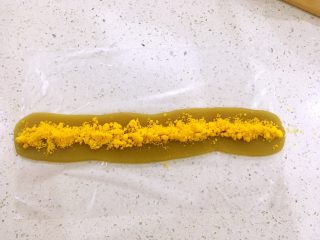 10、一口莲蓉酥,把蛋黄蓉铺在莲蓉的中央位置，如图。