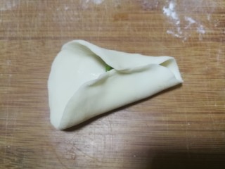 7、金鱼饺子,放了馅料的半边面片对边捏紧作为金鱼肚子部分，注意留出前段不要捏