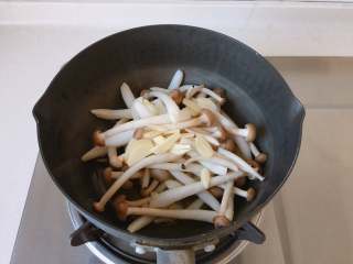 8、油浸蟹味菇拌烤茄子,放入蟹味菇和蒜片，中小火炒制