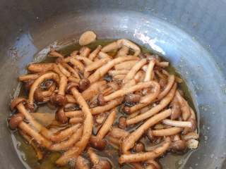 12、油浸蟹味菇拌烤茄子,翻炒均匀，关火浸制备用