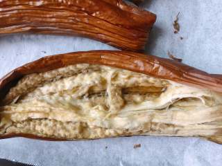 15、油浸蟹味菇拌烤茄子,茄子晾到不烫手时用剪刀剪去头部，扒开一看～里面嫩嫩的，还是有少许汁的哦，一点都不干