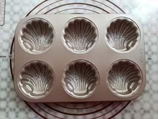 11、炫彩柠檬玛德琳,在模具里抹少量的黄油,筛一层薄薄的面粉,学厨的模具可以省略这个步骤,为了方便大家看,还是在这一步做了抹油和撒粉