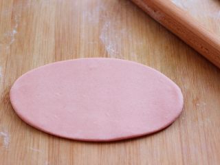 6、花样小螃蟹馒头,把其中的一份再分成两份，其中的一个面团稍微大一些，用于做小螃蟹的主体，另一份留做小螃蟹的腿，把做小螃蟹主体的面团用擀面杖擀成椭圆形。