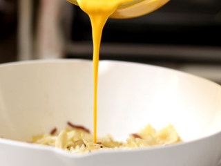 12、培根蛋黄奶油意面,关火后，立刻把调好的奶汁均匀淋在意面上拌匀，用锅的余温把蛋黄奶汁烫熟，迅速拌炒使每片面片上均匀裹上酱汁。这一步很关键，动作一定要迅速灵活，关了火更容易操作。如果不关火，蛋黄奶汁很容易就结块，那样就裹不匀意面了。