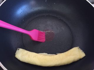 10、寿司玉子烧,卷后的鸡蛋卷靠边，在锅上再刷上一层薄薄的食用油，也可不刷。再倒入剩下的1/2鸡蛋液继续煎至差不多溶固时卷起成卷