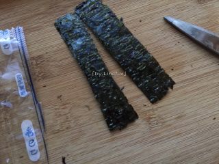13、寿司玉子烧,放凉玉子烧的时间里可以先准备好海苔。将即食海苔用剪刀沿竖向中间剪开，分成两半的小长条状