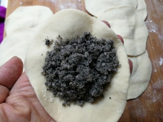 8、黑芝麻糖角包,取一小块幹成中间厚，边缘薄的皮，放入黑芝麻馅