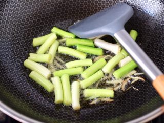 7、蒜苗炒猪肝,另起锅烧热，倒入花生油烧至八成热，先倒入剩下的姜丝和蒜苗白，大火快速翻炒均匀。