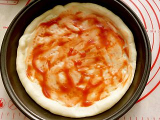 6、大虾披萨,取出饼底后抹上一层番茄酱（或者是披萨酱，根据个人口味添加）