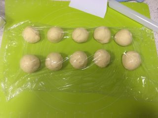 10、日式牛奶面包卷,取出面团按压排气后分割为10份，盖上保鲜膜松弛10分钟