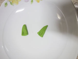 2、丑萌的青团，我们绿的不一样,用刀将面团切出两个三角形，用手稍微整一下型这就是耳朵了。