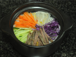 7、韩式砂锅拌饭,将切好的蔬菜和牛肉丝都摆放在米饭上