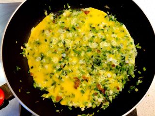 8、荞菜炒鸡蛋,先不要翻动，让鸡蛋液和菜在锅中摊熟。