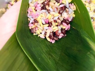 5、????五彩红豆粽子????,把叶子内卷起来不漏米就可以咯