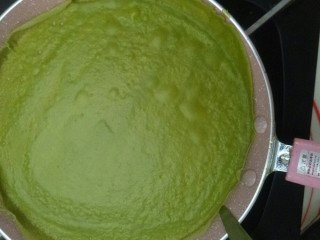 7、薄如蝉翼的抹茶千层,倒入一勺面糊迅速转匀,放瓦斯炉上小火十几秒就好,用刮刀沿着边缘剥离,倒扣到烤网上就好