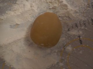9、莲蓉肉松月饼,然后包好它之后 将面团稍微搓圆,在放在生面粉上滚一圈,然后在拍掉多余的面粉(这样做是为了防沾)