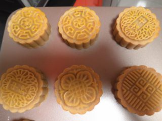 12、莲蓉肉松月饼,七分钟结束后取出烤盘在月饼表面刷上一层蛋黄液!此时烤箱记得要重新预热,温度是176度上下火。刷好后继续送入烤箱 176度上下火10分左右。