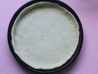 12、鸡肉蔬菜披萨,将擀好的面皮平铺在烤盘上，四周稍微高一点